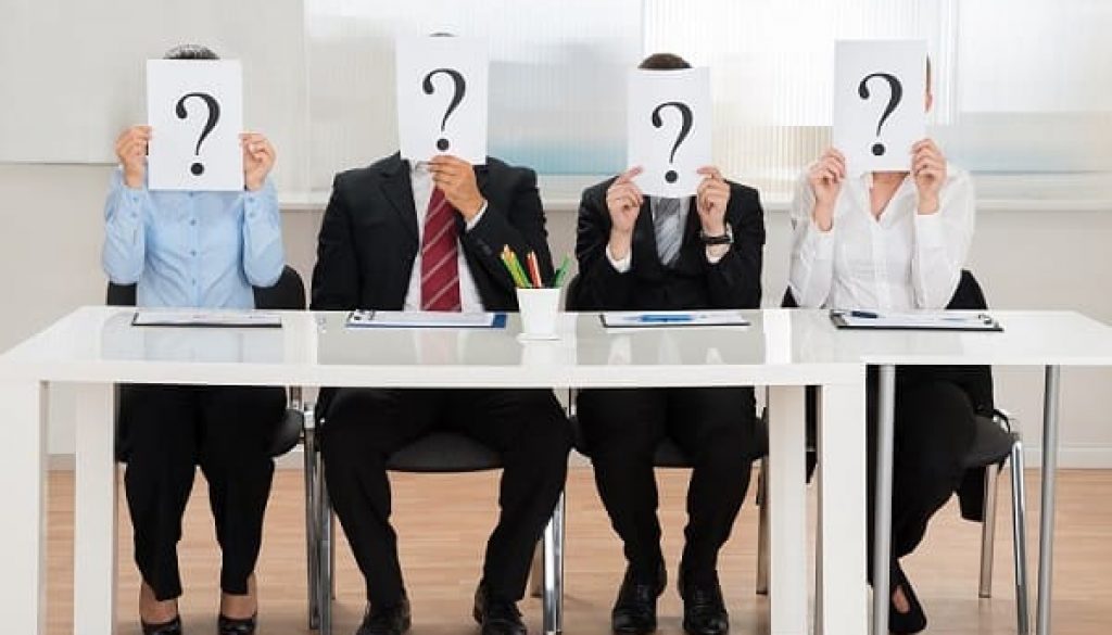 Businesspeople Hiding Face With Question Mark Sign