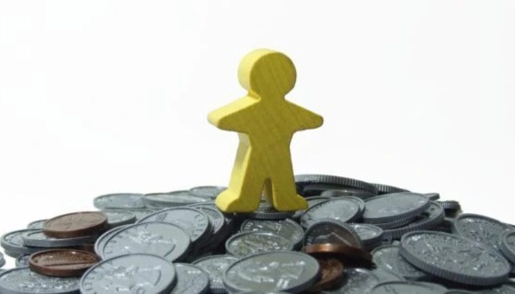 Image of a little yellow man atop a mountain of coins for an article about Why is Tail Spend Management Important but Often overlooked?.