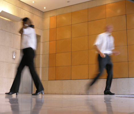 Image of two people running in an office for an article about How to Master Reverse Bidding: A Guide for Strategic Vendors.