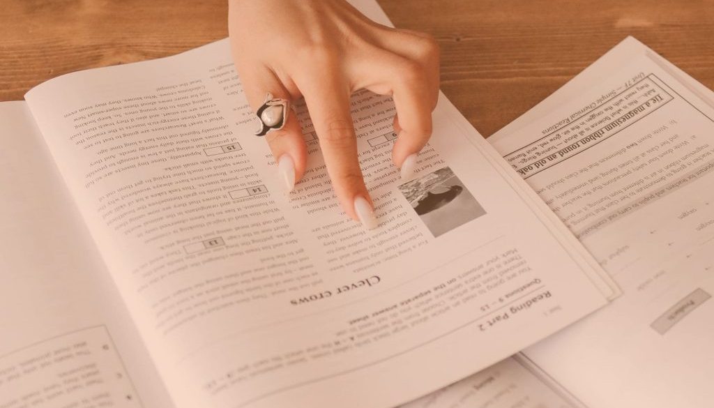 Image of a woman with a pearl ring pointing within a book for an article about Your 2022 Guide to eRFx.